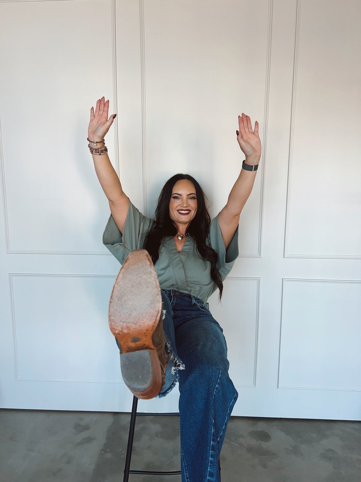 Person posing with a large shoe sole in front of a white paneled wall