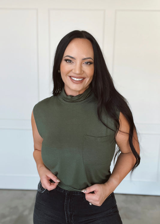 Woman wearing an olive green sleeveless top with a white background
